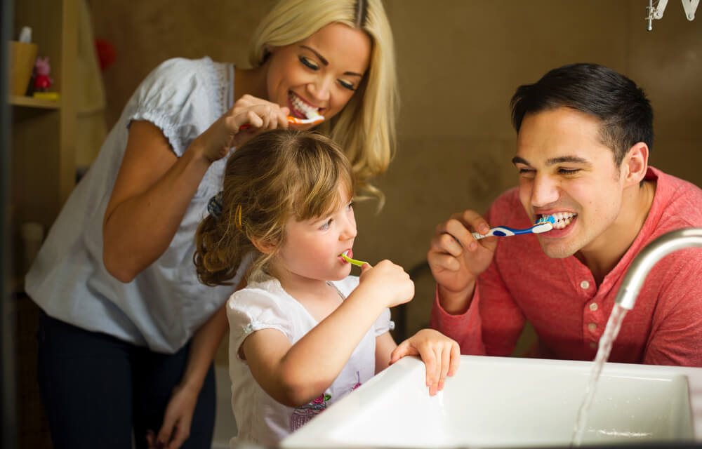 Family brushing their teeth together